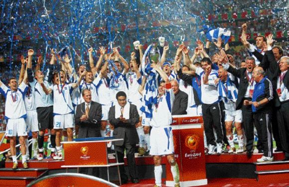 Captain Zagorakis lifts the trophy as the Greeks celebrate their historic feat